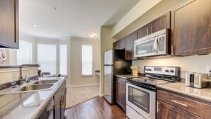 A modern kitchen with stainless steel appliances, wooden cabinets, and a granite countertop. - Serene Escape in the Pines- shopping, dining, entertainment-Iron Man (Spring)