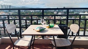 A balcony with a table, two chairs, a glass of water, a bag of chips, and a bag of snacks. - 1BR Haven in Royal Garden Residences (Cebu City)