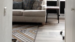 A modern living room with a sofa, a small table, and a view of a cityscape through large windows. - Comfortable and nice Apartment in City of  Guatemala  (Ciudad de Guatemala)