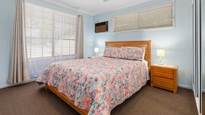 A bedroom with a bed, nightstands, a ceiling fan, and windows with blinds. - "Klinger House" - Redcliffe Q 4020 (Redcliffe)