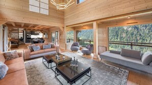 Un interior espacioso de madera con un moderno conjunto de sofás, una mesa de centro de vidrio y una zona de comedor.