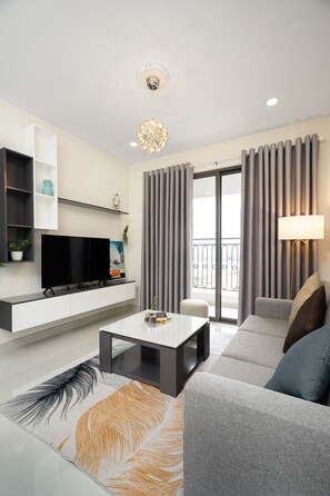 Relax in this stylish living room with a flat-screen TV, comfortable sofa, and a cozy coffee table.