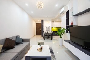 Relax in this stylish living room with a sofa, coffee table, flat-screen TV, and dining area.