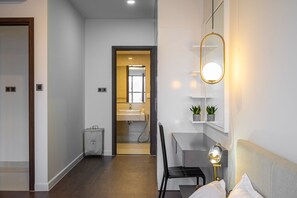 Relax in a serene space with a comfortable bed, a cozy seating area, and a stylish mirror.