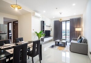 Relax in this inviting living area with a dining table, sofa, and TV.