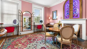 A room with a round wooden dining table, red chairs, a large mirror, and a colorful rug. - Stay in Historic Bucks County Farmhouse
Sleeps 18 -13 beds, 5 baths, 2 kitchens  (Bensalem)