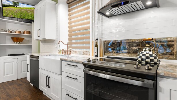 A modern kitchen with white cabinetry, a built-in oven, and a backsplash with a stone-like texture. - Stay in Historic Bucks County Farmhouse
Sleeps 18 -13 beds, 5 baths, 2 kitchens  (Bensalem)