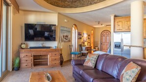 Un salon avec un canapé en cuir, une table basse en bois et un téléviseur.
