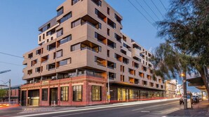 A multi-story building with a modern architectural design, featuring a mix of balconies and large windows. - Artistic Getaway by Artist Abodes (Fitzroy)
