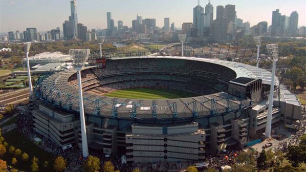 Een groot stadion met een rond ontwerp, omringd door een stadsachtergrond.