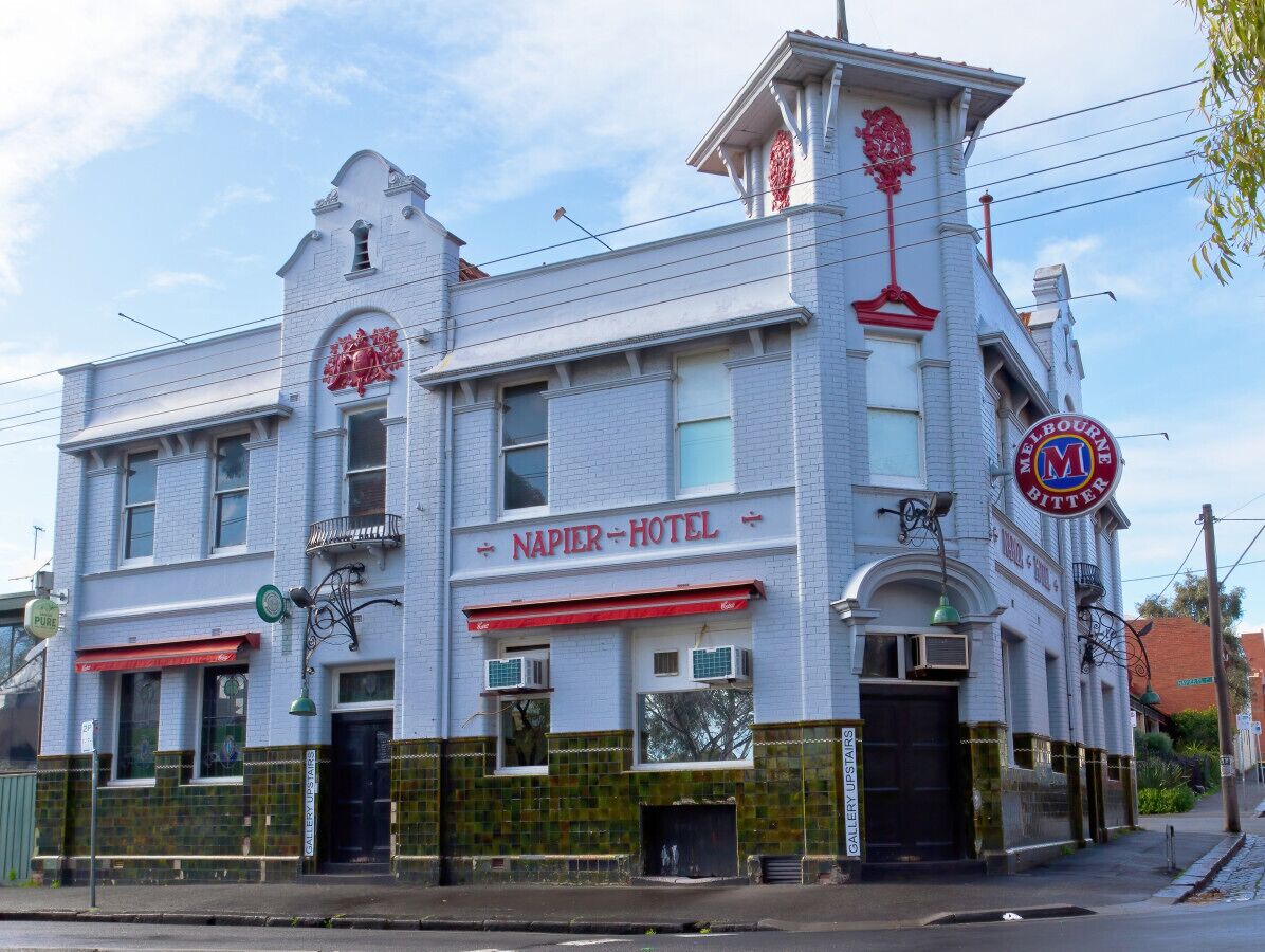Un bâtiment historique sur lequel on peut lire l’inscription « HÔTEL NAPIER » et une autre inscription indiquant « MELBOURNE BITTER ».