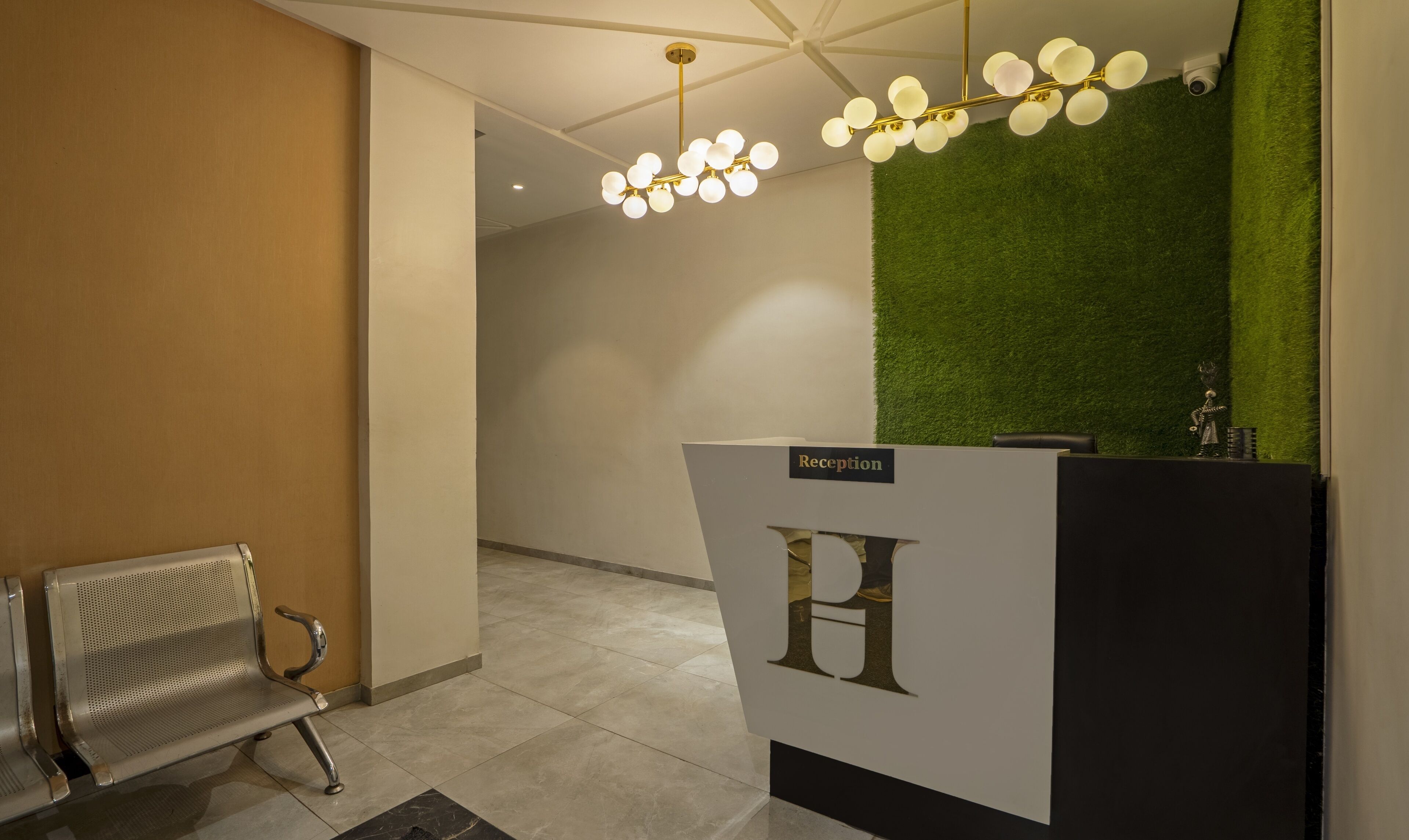 A reception desk with a 'Reception' sign, a bench, and a green wall.