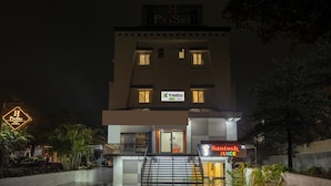 A multi-story building with a sign for 'Prasha Hotels & Banquets' and 'treebo trend Prasha'. - Treebo Prasha (Nashik)