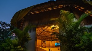 A thatched-roof structure with a wooden interior, surrounded by greenery. - Prakriti The Nature Resort Pushkar (Pushkar)