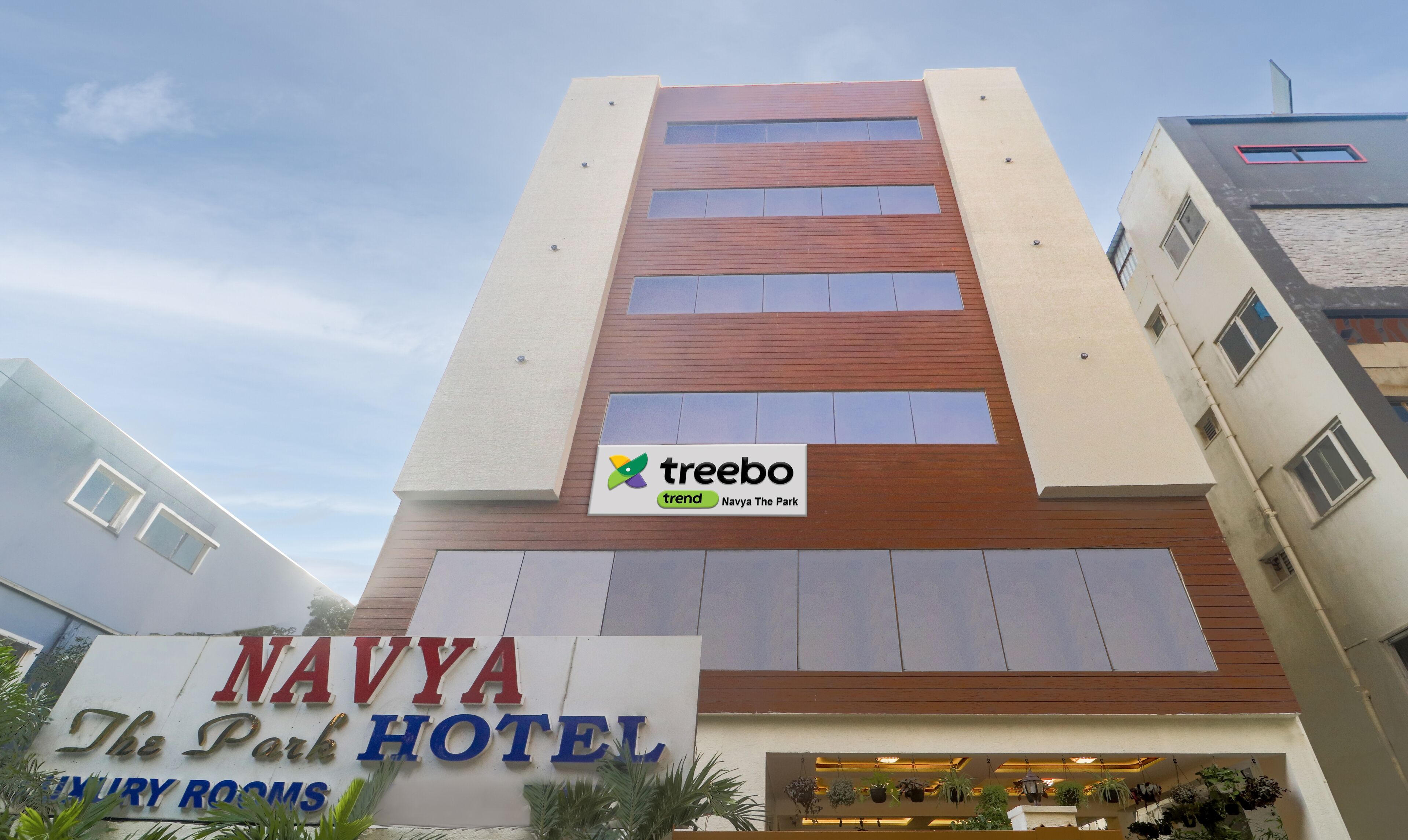 Navya Park Hotel, med en skylt som visar att hotellet erbjuder lyxiga rum.