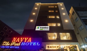 A hotel with a sign for 'Navya The Park' and 'treebo trend' indicating a modern building with multiple floors and star-shaped lights on the facade.