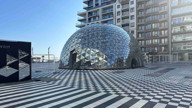 A modern spherical building with a geometric facade, surrounded by a checkered pavement and adjacent high-rise buildings. - Luxurious 5-Bedroom Holiday House in Knokke-Heist Belgique (Knokke-Heist)