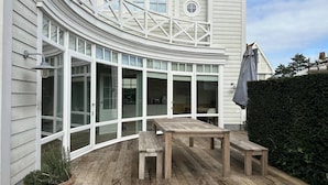 A curved exterior with large windows, a wooden deck, and a potted plant. - Luxurious 5-Bedroom Holiday House in Knokke-Heist Belgique (Knokke-Heist)
