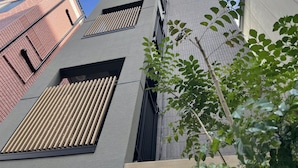 Un edificio moderno con techo inclinado, ventanas amplias y una antena visible en la azotea.