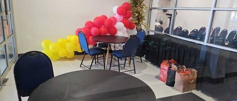 A conference room with a round table, blue chairs, and a balloon arrangement.