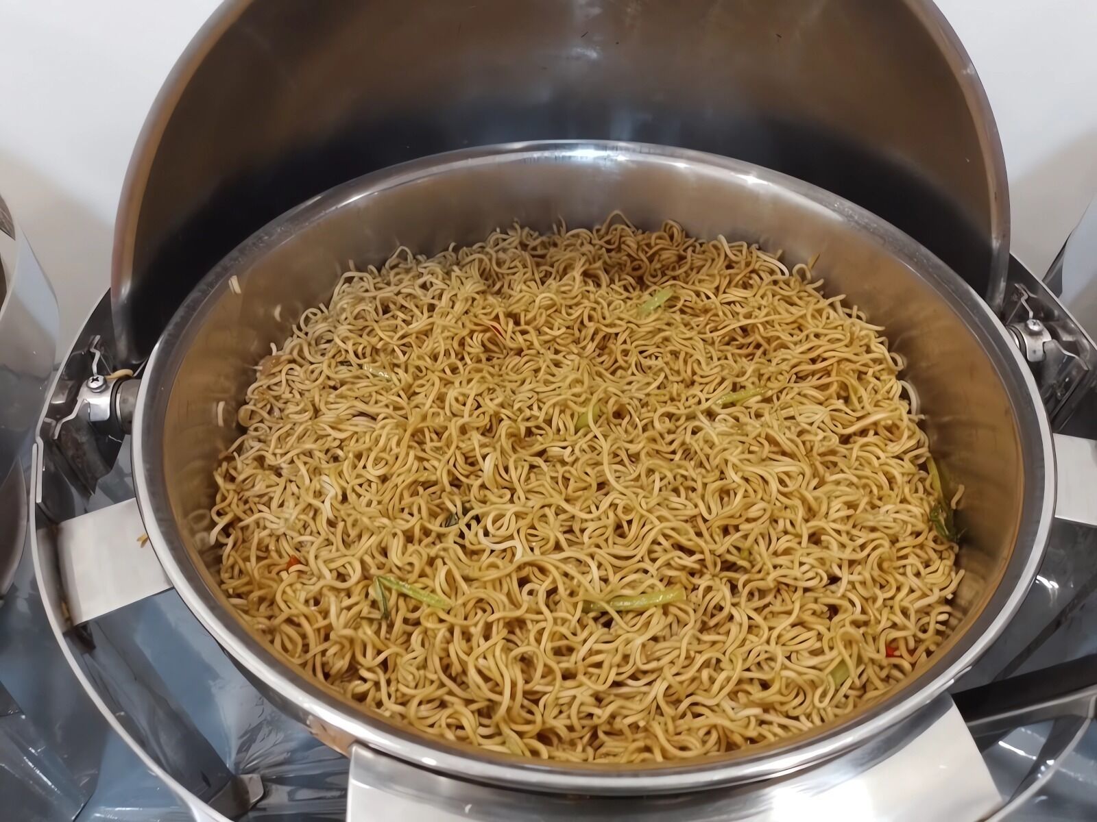 A stainless steel pot filled with cooked noodles.