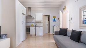 Una cucina moderna con mobili bianchi, forno integrato e cappa aspirante in acciaio inossidabile.
