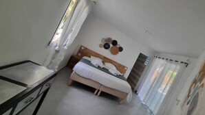 Ein Schlafzimmer mit Bett, Schreibtisch und Fenster.