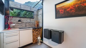 Cocina moderna con salpicadero de piedra, ventana y un cuadro de amapolas.