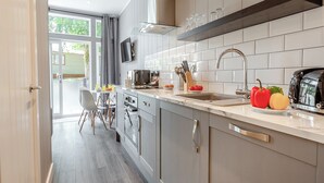 Eine moderne Küche mit einer großen Kochinsel, einem eingebauten Backofen und einem Flachbildfernseher.
