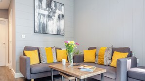 Ein modernes Wohnzimmer mit einer Sofagarnitur, einem Couchtisch und einem Bild an der Wand.