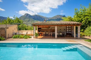 A poolside area with a covered patio, a pool, and mountains in the background. - Villa Rae with Mountain View, Wi-Fi, Garden, Terrace & Pool (Sóller)