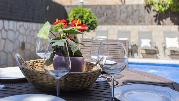 Una mesa de comedor con una cesta de nueces, un vaso de agua y una copa de vino.