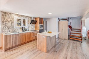 Una cucina moderna con isola centrale, elettrodomestici integrati e pavimento in legno.