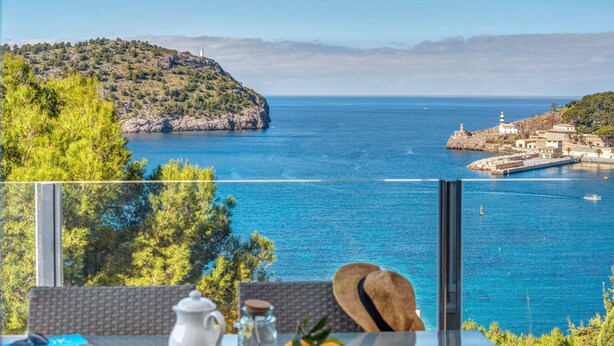 Una mesa con alimentos para el desayuno y vistas al mar y un faro.