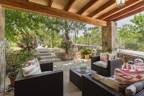 An outdoor patio with wicker furniture, stone steps, and potted plants. - Fantastic Villa with Pool, Whirlpool, Terraces, Mountain View, Air Conditioning & Wi-Fi (Sóller)