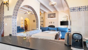 Una cocina moderna con encimera negra, cafetera y una botella de vino.