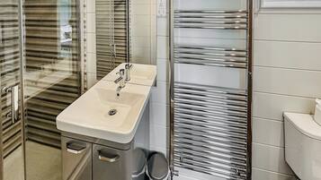 A bathroom with a modern sink, a glass shower enclosure, and a toilet.