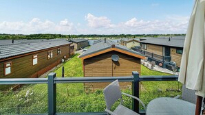 Un barrio residencial con varias casas de madera, un jardín con césped y cielo despejado.