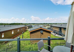 A residential area with multiple wooden buildings, a grassy yard, and a clear sky.
