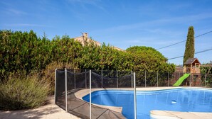 A swimming pool with a safety fence, a slide, and a wooden play structure. - Maison Roxane with Pool, Private Terrace, and Wi-Fi (Six-Fours-les-Plages)