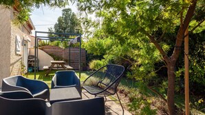 A patio with outdoor furniture, a wooden table, and a metal chair. - Maison Roxane with Pool, Private Terrace, and Wi-Fi (Six-Fours-les-Plages)