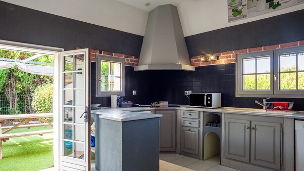 A kitchen with a large island, a microwave, and a sink. - Maison Roxane with Pool, Private Terrace, and Wi-Fi (Six-Fours-les-Plages)