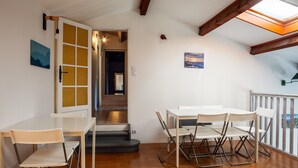 A room with a wooden floor, a white table with chairs, a door with glass panels, and a staircase leading to another room. - Maison Roxane with Pool, Private Terrace, and Wi-Fi (Six-Fours-les-Plages)