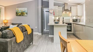 Un appartement moderne comprenant un salon, une cuisine et un coin repas.
