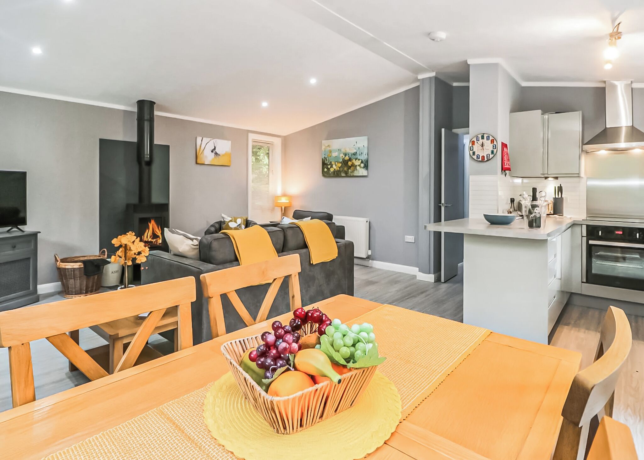 A modern apartment with a dining area, kitchen, living room, and a fireplace.