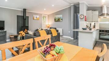 A modern apartment with a dining area, kitchen, living room, and a fireplace.