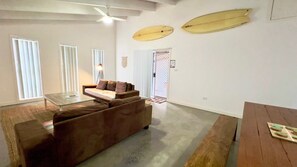 Un soggiorno con un divano, un tavolino da caffè e due tavole da surf montate sulla parete.