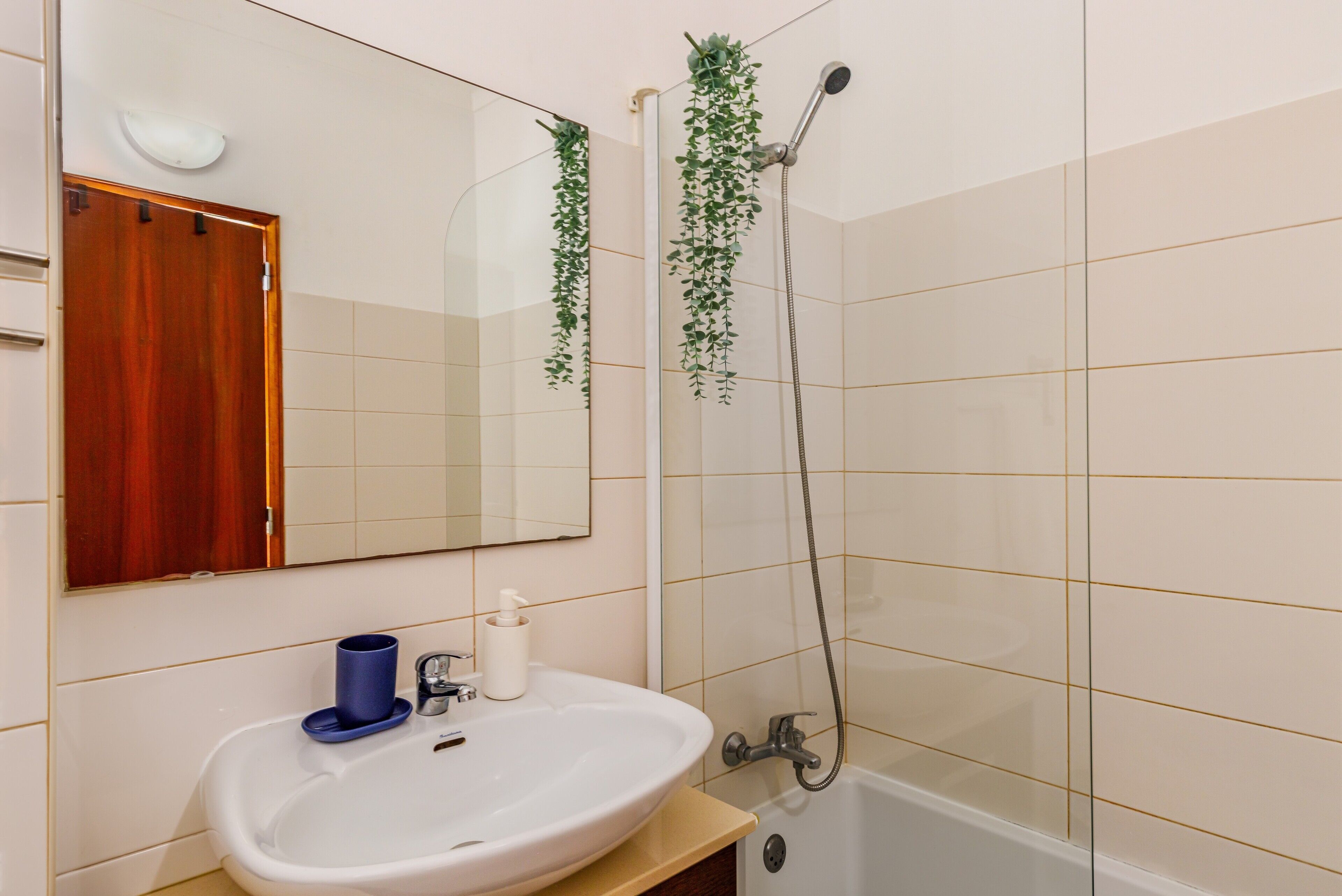 Un bagno con lavandino, specchio e doccia.