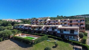 A multi-story residential building with a courtyard, surrounded by greenery. - Holiday Home "Casa OriMar 419" with Shared Pool and Wi-Fi (Badesi)