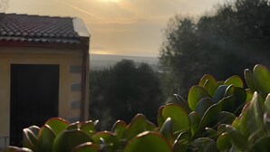 A building with a tiled roof and a door, surrounded by green plants. - Holiday Home "Casa OriMar 419" with Shared Pool and Wi-Fi (Badesi)